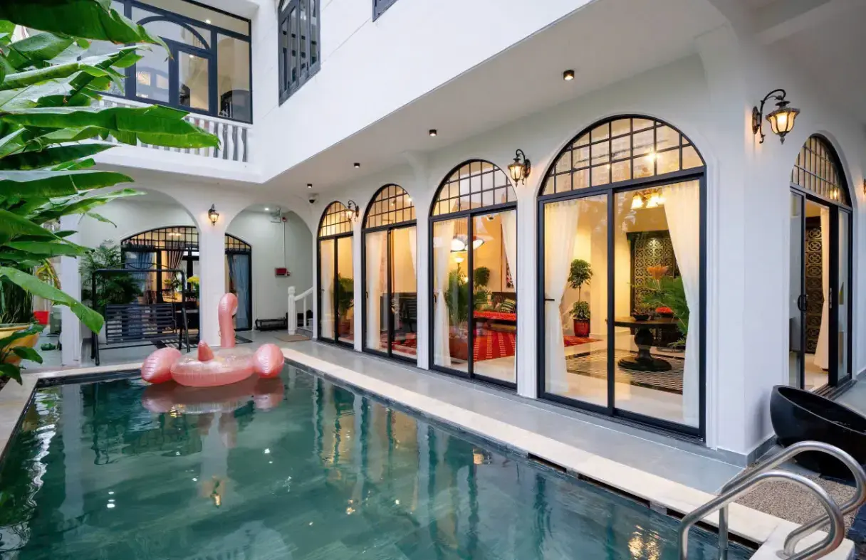 Courtyard swimming pool of a classic Da Nang villa featuring arched windows and tranquil ambiance
