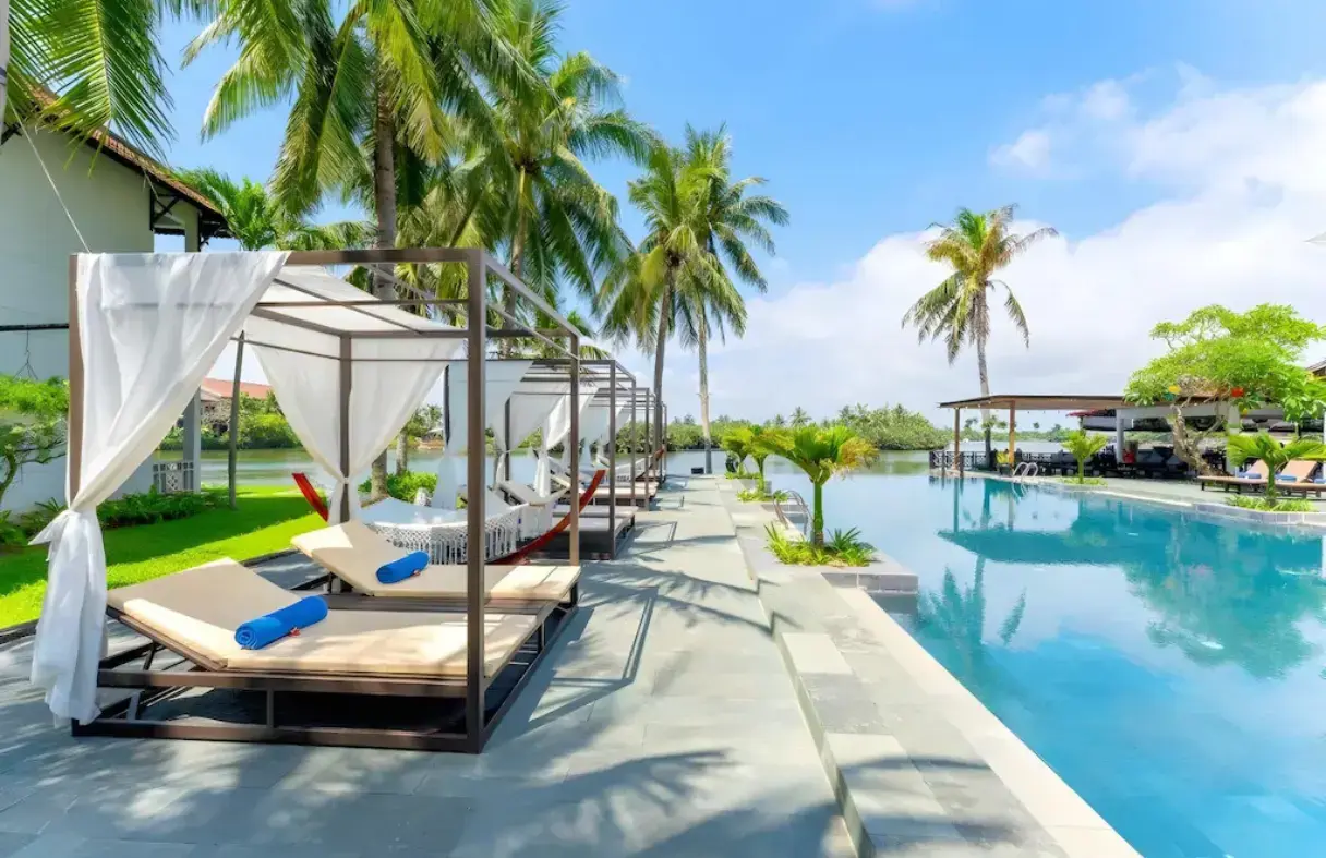 Hồ bơi ngoài trời tại Hoi An Beach Resort với không gian xanh mát