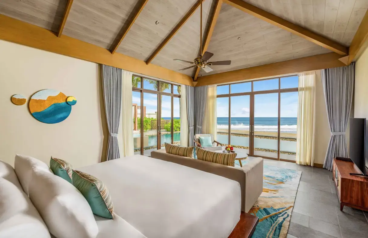 Elegant master bedroom in a Da Nang villa featuring a king-size bed, sophisticated décor, and balcony access.