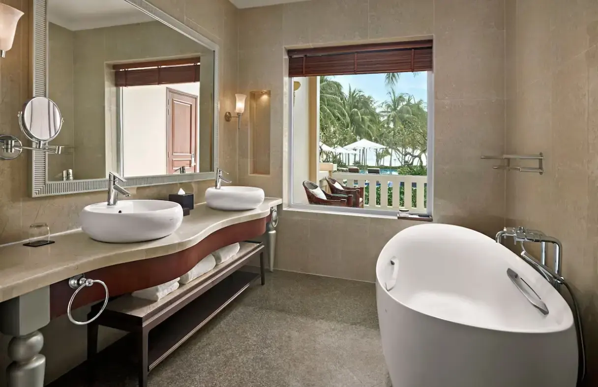 Luxury villa bathroom in Da Nang with bathtub, garden view, and marble finishes