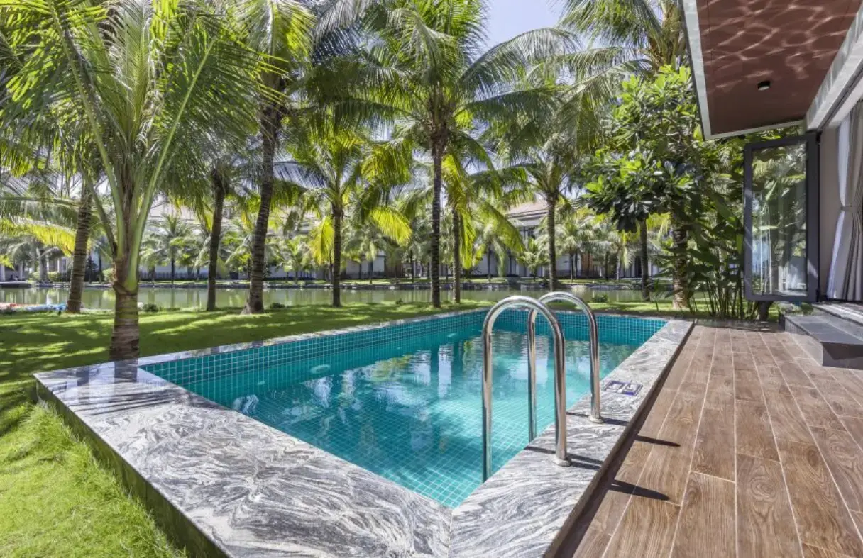 Private swimming pool surrounded by a garden at a sea view villa in Da Nang