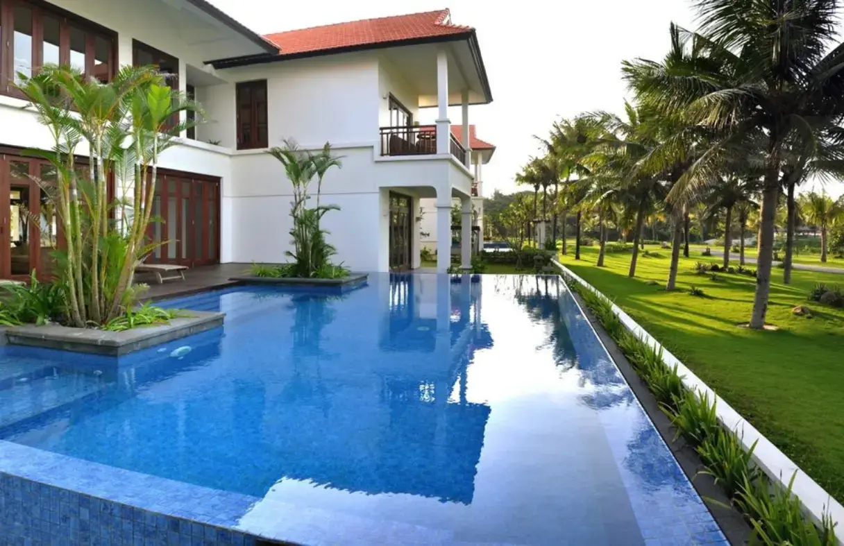 Guests enjoying a peaceful morning coffee on the balcony of their Da Nang beach villa with panoramic sea views.