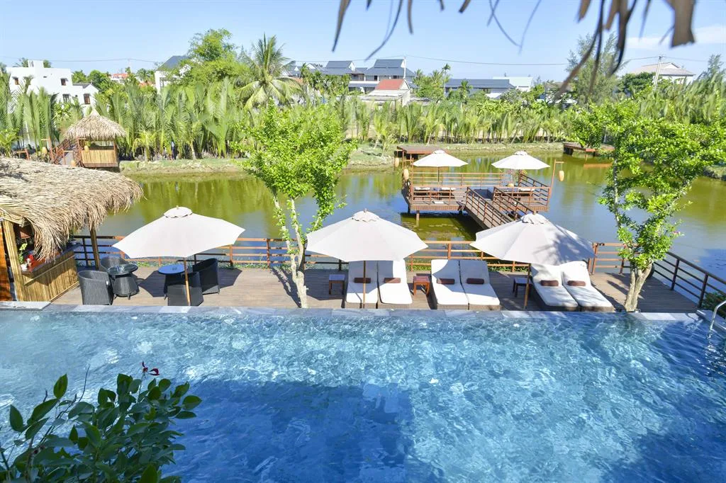 Hồ bơi ngoài trời được bao quanh bởi cây xanh nhiệt đới.