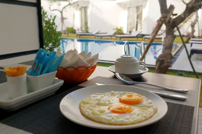Khởi đầu ngày mới với bữa sáng và khung cảnh hồ bơi xanh mát.