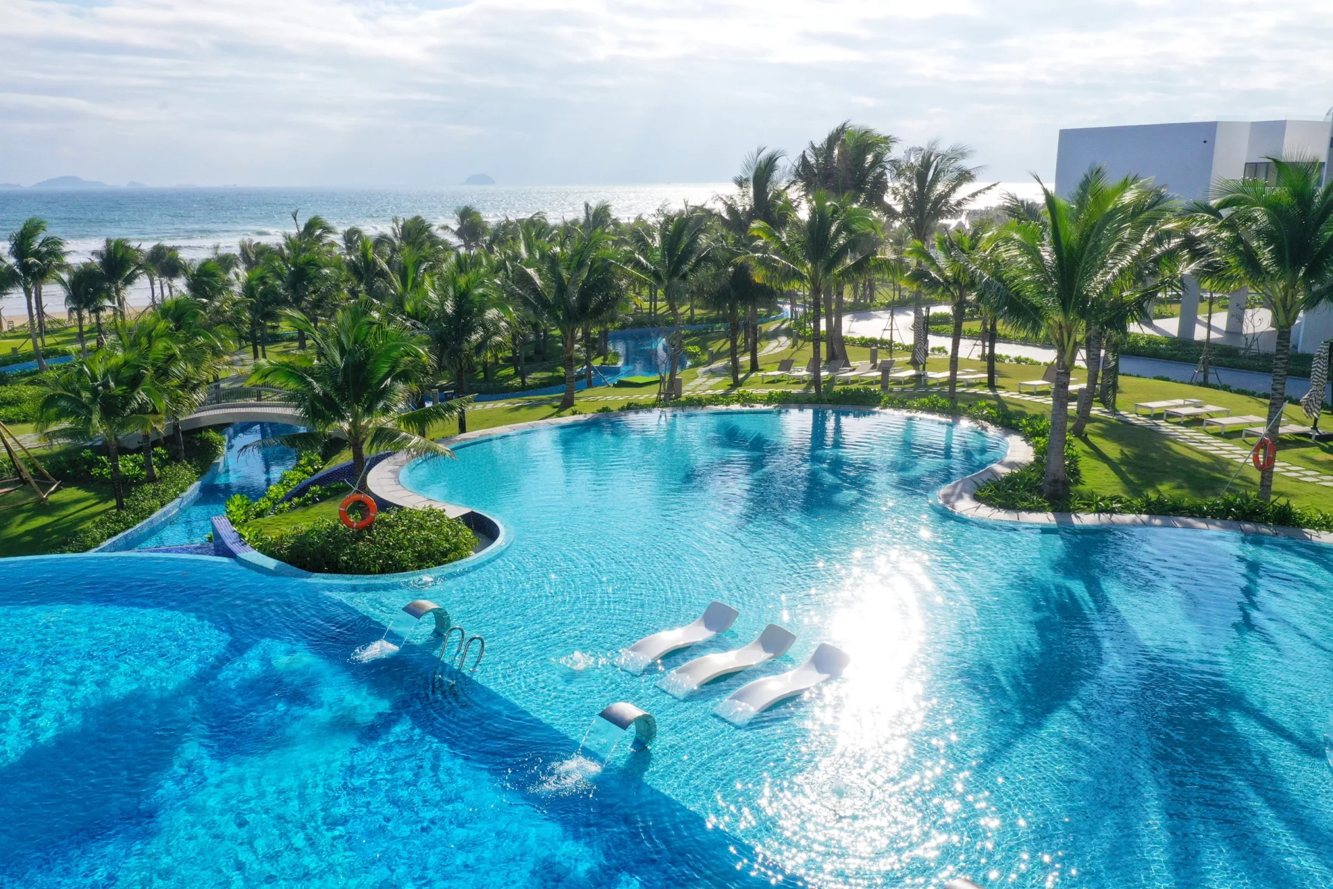 Hệ thống hồ bơi rộng giữa khu vườn xanh là điểm vui chơi và thư giãn nổi bật dành cho gia đình tại The Empyrean Cam Ranh.